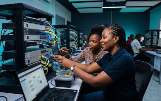 Instructor and student working on network switches in a hands-on networking lab
